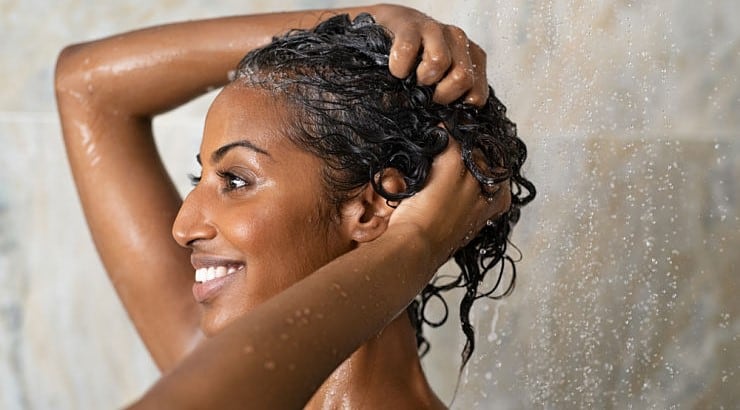 Black girl washing her hair for growth